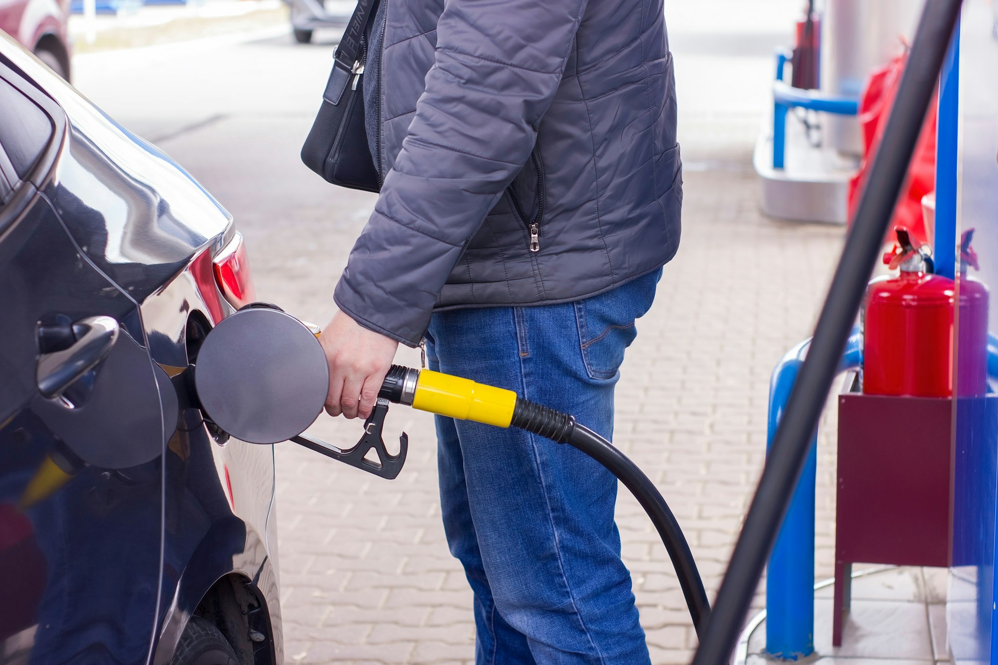 Man refuelling a car at a petrol station.